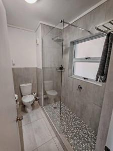 ein Badezimmer mit Dusche und Toilette und einem Fenster in der Unterkunft Brookes Hill Suites Bay Watch in Summerstrand + 8 Fotos