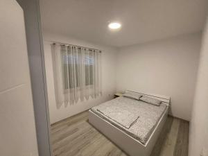 a small bedroom with a bed and a window at PrishtinaRoyalty in Pristina
