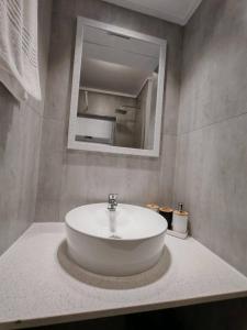 ein Badezimmer mit einem weißen Waschbecken und einem Spiegel in der Unterkunft Brookes Hill Suites Bay Watch in Summerstrand