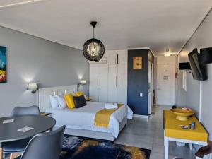 ein Hotelzimmer mit einem Bett und einem Tisch in der Unterkunft Brookes Hill Suites Bay Watch in Summerstrand