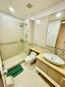 une salle de bain avec un lavabo, des toilettes et une douche dans l'établissement Apartamento Tres habitaciones frente al mar, à Estación El Salto 20 autres photos