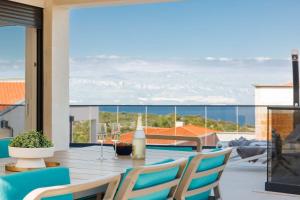 a table and chairs on a patio with a view of the ocean at Holiday house with a swimming pool Vrbnik, Krk - 24519 in Vrbnik