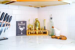 Una encimera de cocina con una encimera con botellas y cuchillos. en Jungle House Columbus Short North Downtown Free Parking - Walk to Convention Center & Nationwide Arena - 4BR Luxury Home - Sleeps 20 - Over 5,800 Five Star Stays, en Columbus