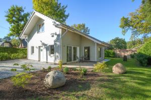 a white house with rocks in the yard at Am Hafen 21 in Zislow