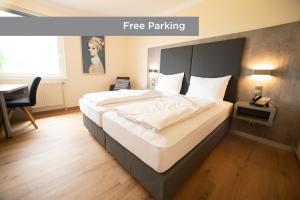 una habitación de hotel con cama y aparcamiento gratuito en Das Reinisch Just Rooms, en Schwechat