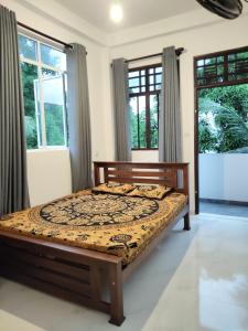 Un dormitorio con una cama en una habitación con ventanas. en Galhena Apartments, en Tangalle