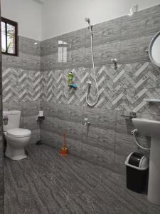 Un baño con inodoro y ducha. en Galhena Apartments, en Tangalle