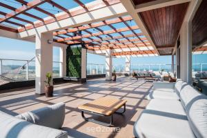 a living room with couches and a table at Estúdio em Cond. c/ Pisc. a 550m Praia TOR0407 in Imbituba