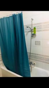 La salle de bains est pourvue d'un rideau de douche bleu à côté d'une baignoire. dans l'établissement Casa Vacanze Piazza Europa, à Milazzo