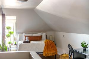 a bedroom with a bed with a yellow blanket on it at Jungle House Columbus Sleep 16 Downtown Ohio Free Parking - Near Convention Center & Nationwide Arena - 4BR Luxury Home - Pet Friendly - Over 5,800 Five Stars in Columbus