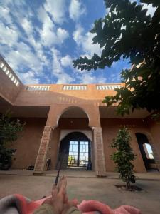 a person laying in front of a building at AISHAMA Healing House in Aït Ourir