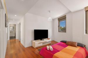 a bedroom with a bed and a flat screen tv at Ínsula Home in Tamaraceite