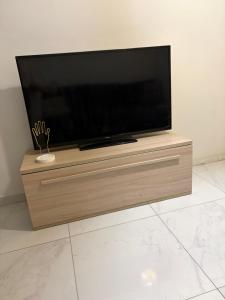 a flat screen tv sitting on top of a wooden entertainment center at Tedds Cosy 2 bedroom Apartment in Tal-Pietà