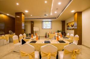 une salle de banquet avec des tables et des chaises avec des archets jaunes dans l'établissement Hotel Kapish Smart-All Pure Veg, à Jaipur