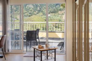 ein Wohnzimmer mit Tisch und großem Fenster in der Unterkunft Cantinho das Feiteiras by Homie in São Vicente