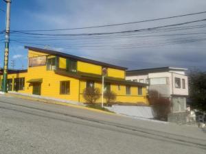 un edificio amarillo al costado de una calle en Amanecer de la Bahía, en Ushuaia