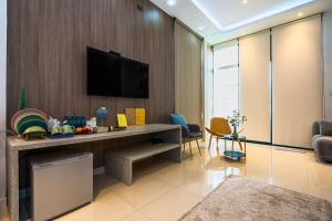 een woonkamer met een televisie aan de muur bij Ellie House Phuket Old Town in Ban Rangeng +52 foto's