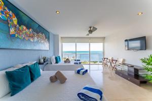 ein Wohnzimmer mit Sofa und Fernseher in der Unterkunft Beach Front Apartment with beach access AMARA in Cancún