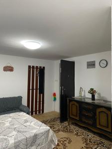 a bedroom with a bed and a dresser and a clock at Vikendica- kuća za odmor in Goražde +6 photos