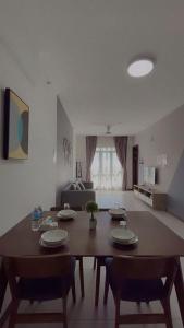 Una sala de estar con una mesa y sillas de madera. en K AVENUE FAMILY ROOM B09 near airport by Gc, en Donggongon