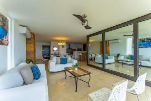 ein Wohnzimmer mit weißen Sofas und einem Tisch in der Unterkunft Beach Front Apartment with beach access AMARA in Cancún