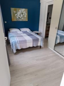 um quarto com uma cama e uma parede azul em Ti case Les Girofles em Saint-Benoît