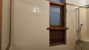 a bathroom with a shower with a window and a glass door at nelli house in Galle