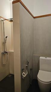 a bathroom with a toilet and a roll of toilet paper at nelli house in Galle