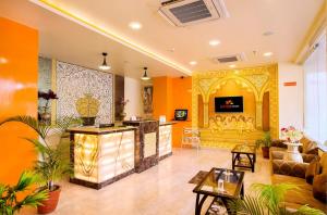 een woonkamer met oranje muren en een lobby bij Hotel Kapish Smart-All Pure Veg in Jaipur