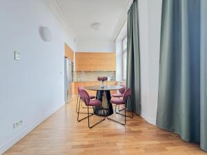 弗罗茨瓦夫Prestige Apartment - Elegant & Quiet Stay 3 rooms 90m2 - AS Home Apartamenty Rynek 508的一间带桌子和粉红色椅子的用餐室