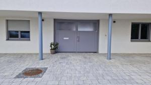 ブライテンブルンにあるAppartements Stadlerの2本の青いポールが付いた建物の正面玄関