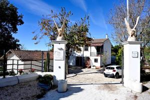 a white house with a gate with two trees at B&B Resort Tina in Gesualdo
