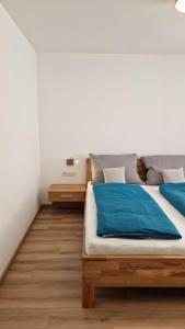 ブライテンブルンにあるAppartements Stadlerのベッドルーム1室(青いシーツが置かれたベッド1台付)
