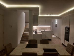 een keuken en een woonkamer met een tafel en een trap bij Sunsets Duplex Penthouse Gozo in Kerċem