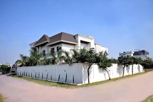 a white fence with trees on top of it at FLORENTINO The Luxury Villa in Amritsar
