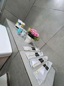 a counter with white towels and flowers on it at K avenue B3A 2bed studio room in Donggongon