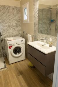 een badkamer met een wasmachine en een wastafel bij Le Casarelle in Gaeta