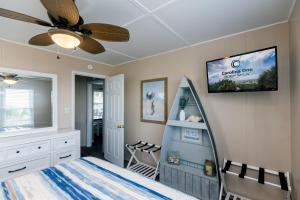 een slaapkamer met een bed en een tv aan de muur bij Beach Retreat in Edisto Island
