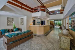 ein Wohnzimmer mit Couch und Bar in der Unterkunft Flat estudio 110 Amarilis Riviera de São Lourenço, 03 piscina climatizada, serviço de hotelaria, limpesa e troca de toalhas diária, carregador veiculo elétrico e servico de praia finais de semana WiFi 500 in Riviera de São Lourenço