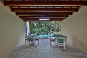 ein Esszimmer mit Tischen, Stühlen und einem Pool in der Unterkunft Flat estudio 110 Amarilis Riviera de São Lourenço, 03 piscina climatizada, serviço de hotelaria, limpesa e troca de toalhas diária, carregador veiculo elétrico e servico de praia finais de semana WiFi 500 in Riviera de São Lourenço