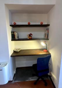 een bureau in een kamer met een blauwe stoel bij Perugia Historic center house in Perugia