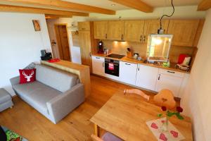 un salon avec un canapé et une cuisine dans l'établissement Ferienwohnung Holzfäller, à Vorderfalkau