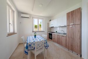 een keuken met een tafel met een tafelkleed erop bij Villa Marilena in Marina di Casalvelino +30 foto's