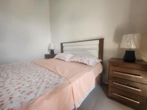 a bedroom with a bed and a dresser with a lamp at Apartamento T1 Mobilado Espargos/Sal in Espargos