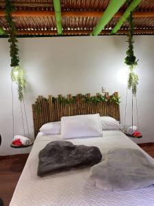 a bedroom with a large bed with a wooden headboard at Eco Hotel Green Eden in Pereira