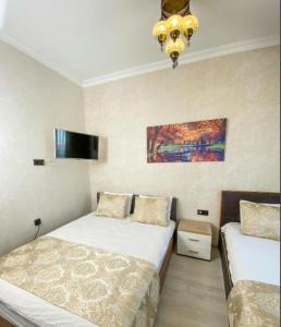 a bedroom with two beds and a chandelier at My Home Premium in Sultanahmet