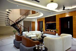 a living room with a spiral staircase and white furniture at FLORENTINO The Luxury Villa in Amritsar
