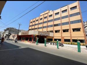 a large building on the side of a street at The Moris palace hotel in Rajkot