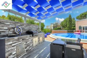 a patio with a kitchen and a swimming pool at Villa Irene in Castiglioncello by TuscanyWeGo in Chioma