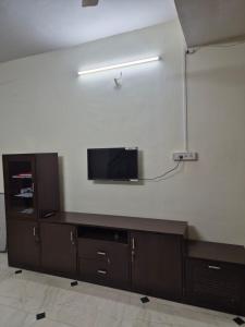 a living room with a tv on a wall at Elite Stays Viman Nagar in Pune +30 photos